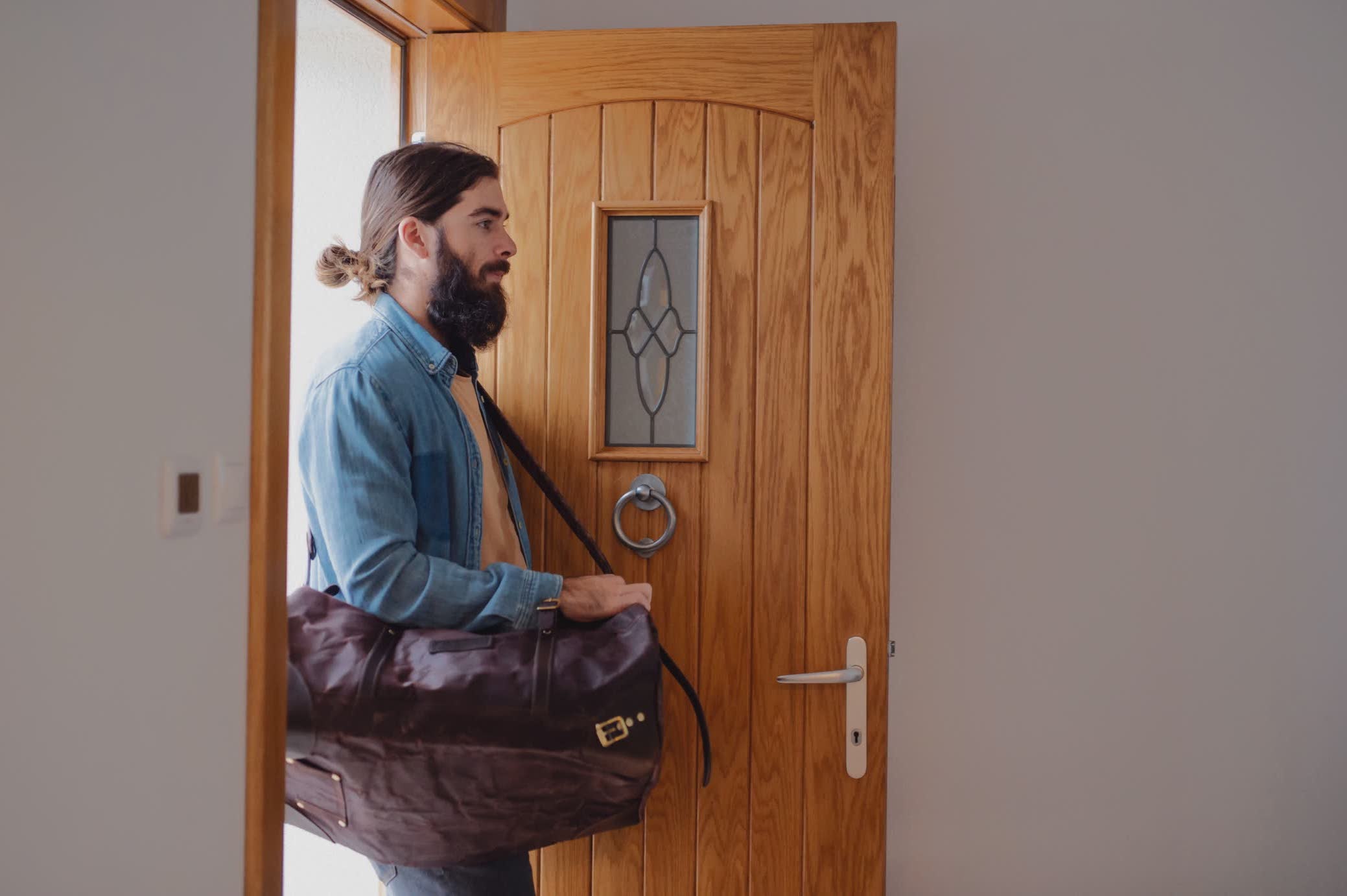 Young man entering a front door