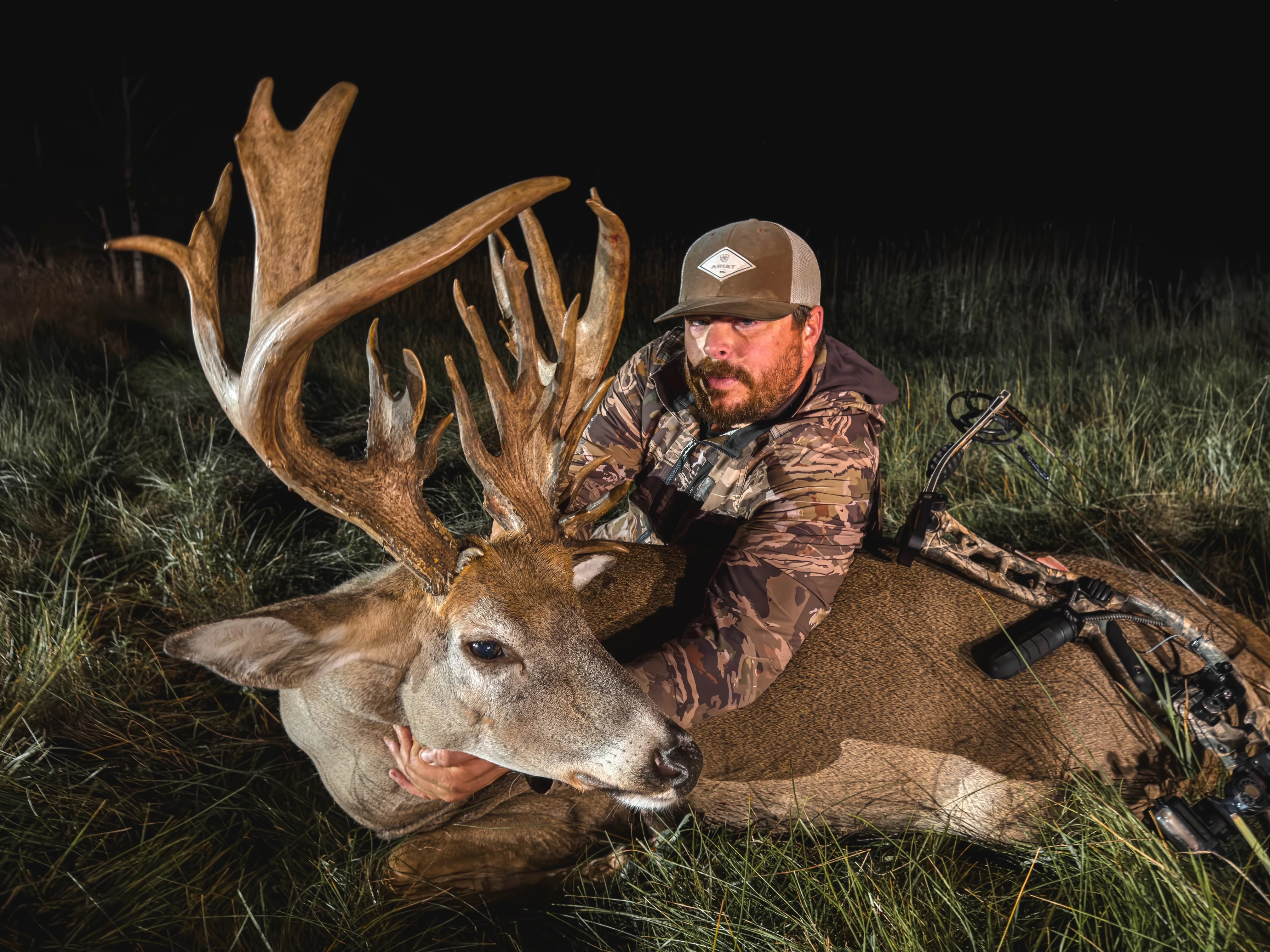 A hunter poses with a 218-inch nontypical whitetail buck, taken with a bow. 