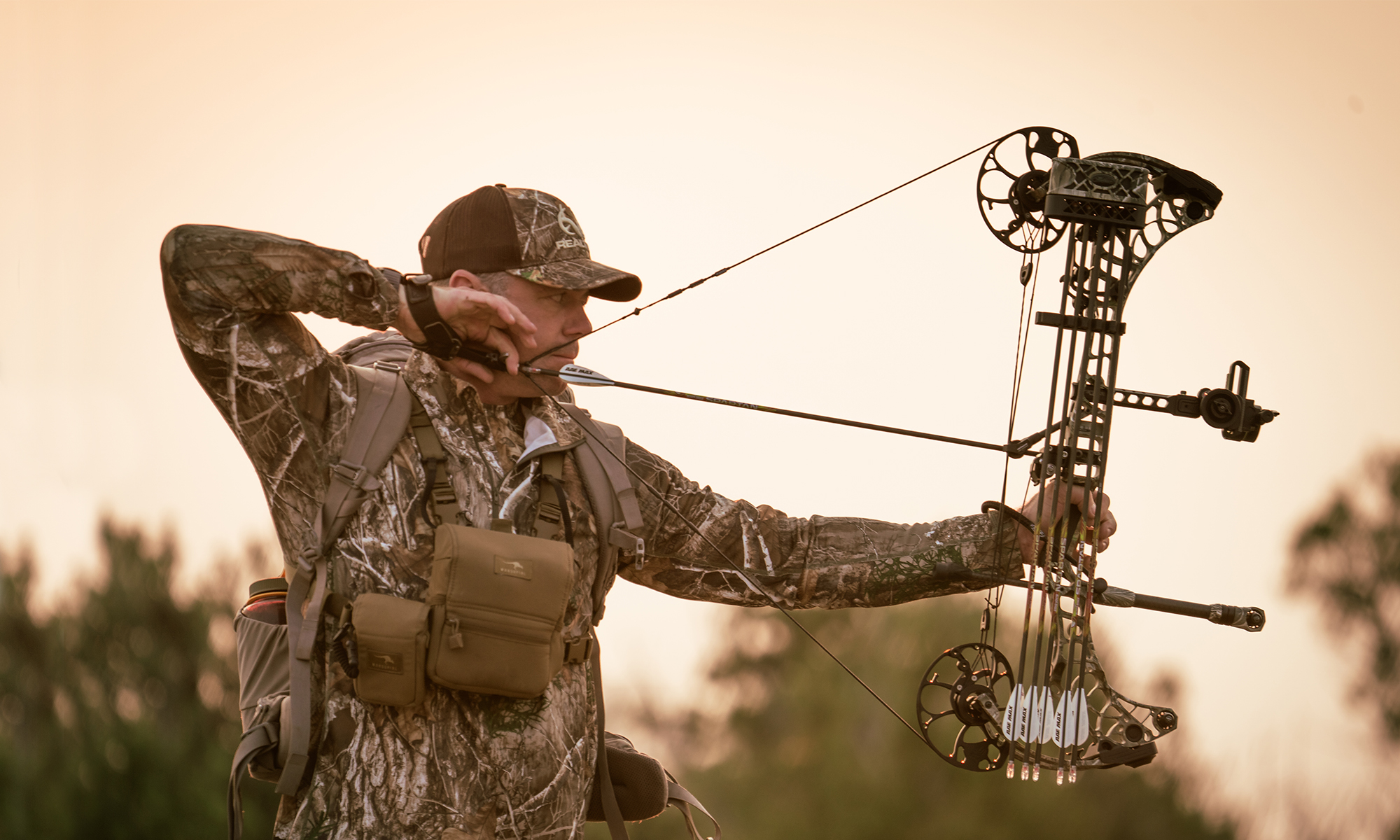 An archer shoots a compound bow into a paper tuning jig. 