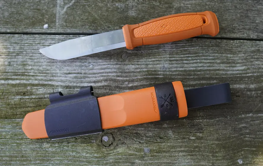 Close-up of Morakniv Kansbol knife and sheath on wood table