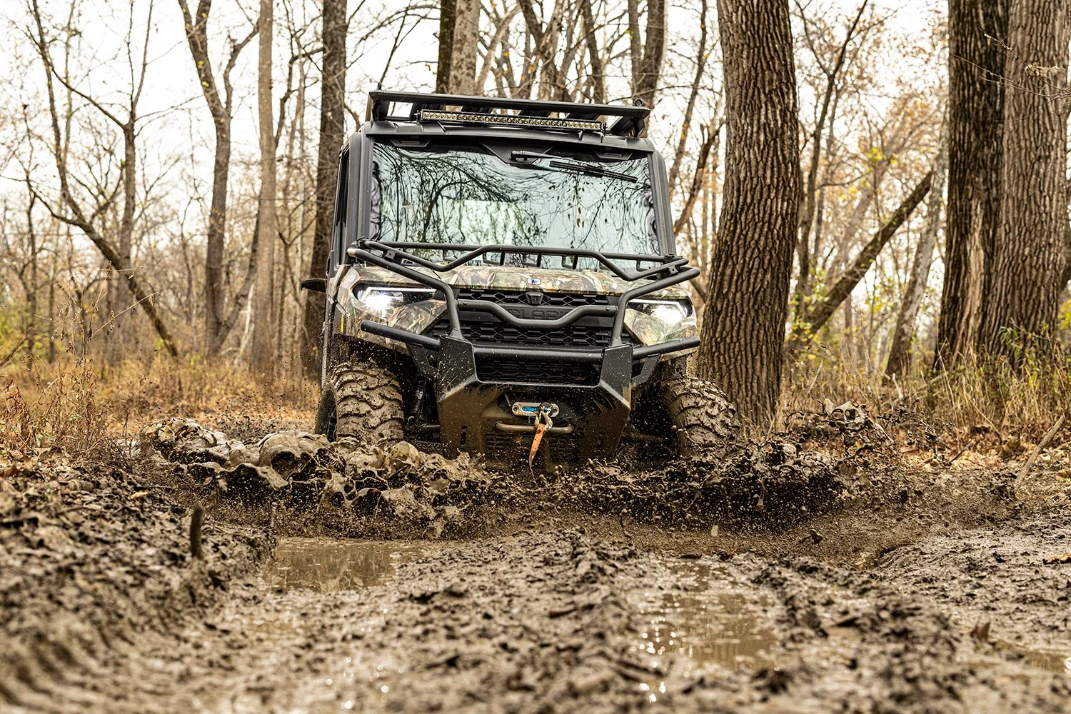 utv drives through very wet muddy terrain