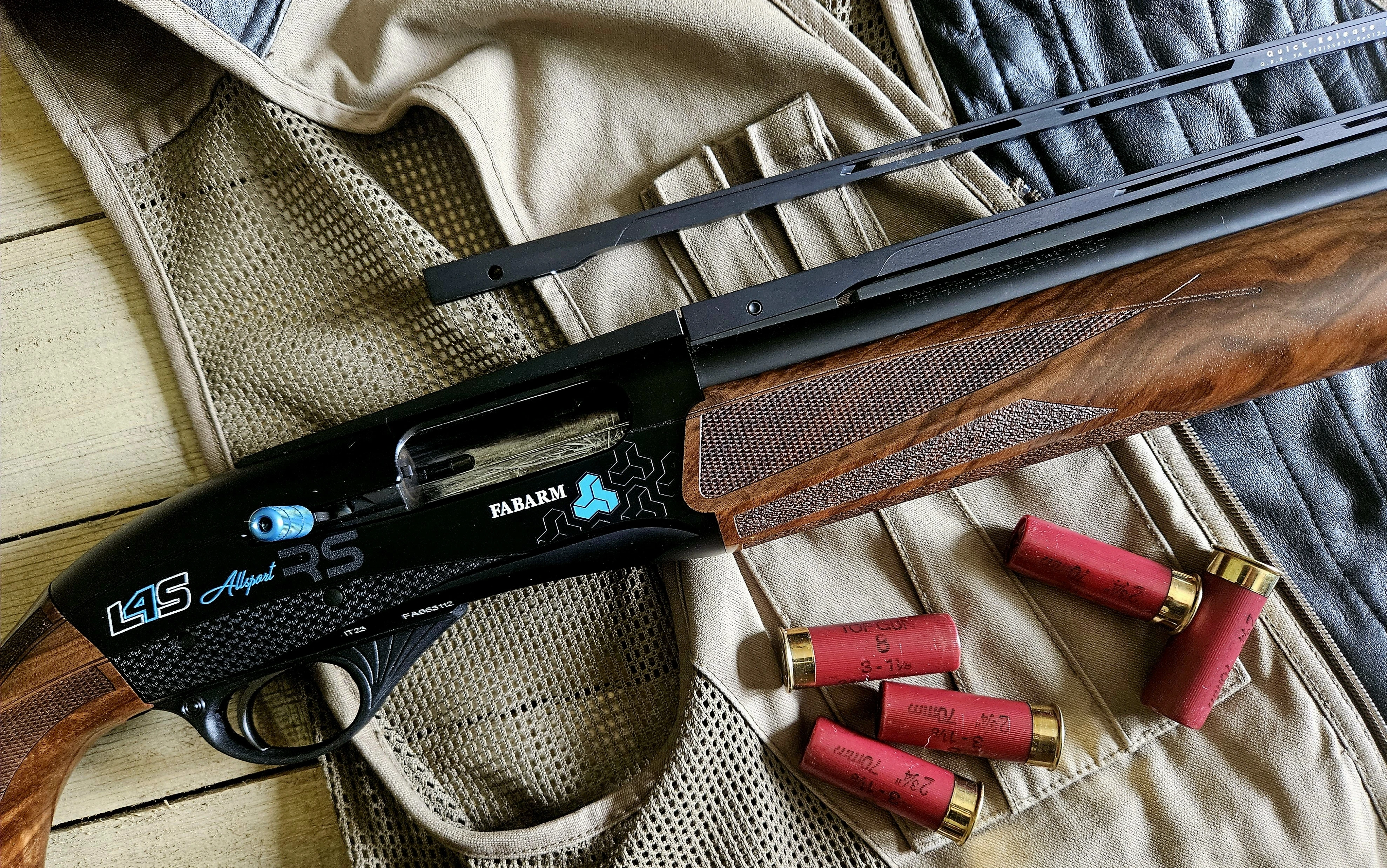 The new Fabarm L4S Allsport shotgun lying on a shooting vest with shotgun shells. 