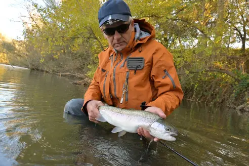 An angler with a large rainbow trout.