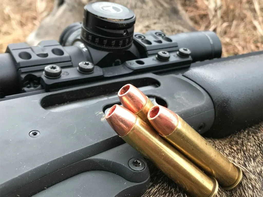 Rifle ammo leaning against a rifle.