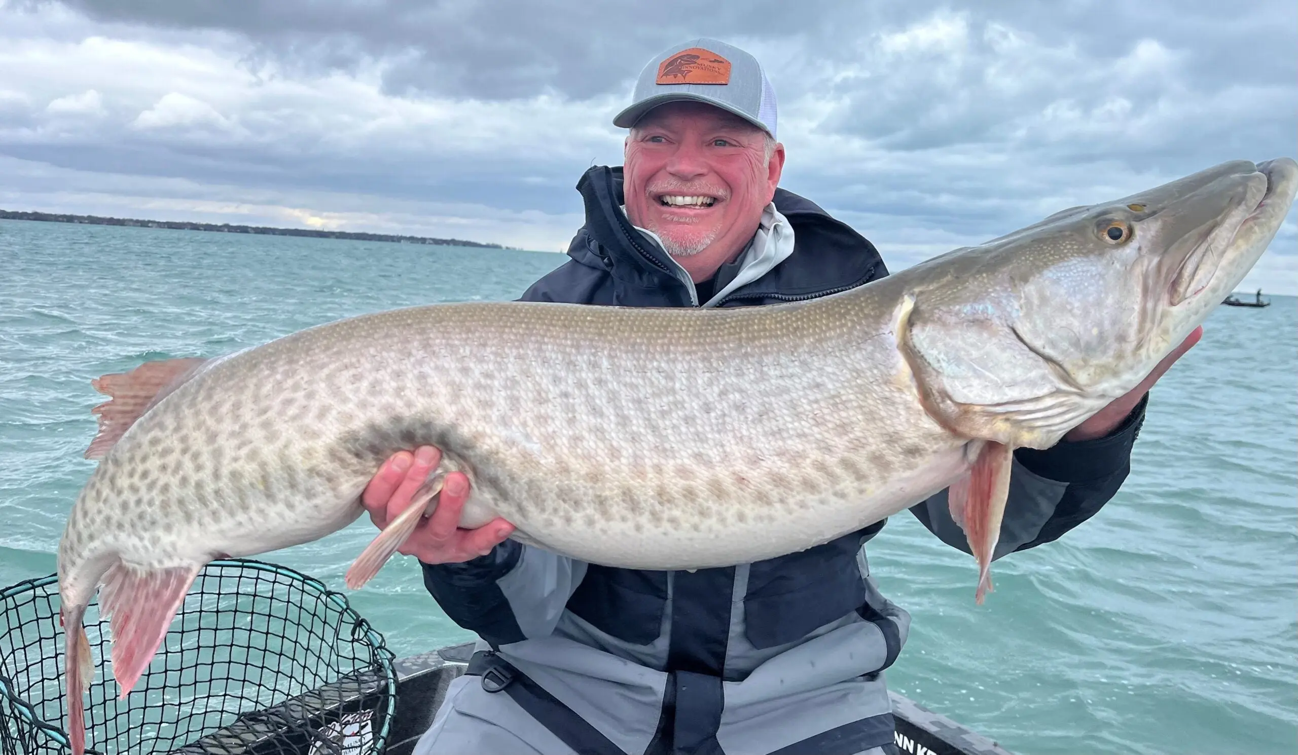 photo of an angler holding up a huge muskie