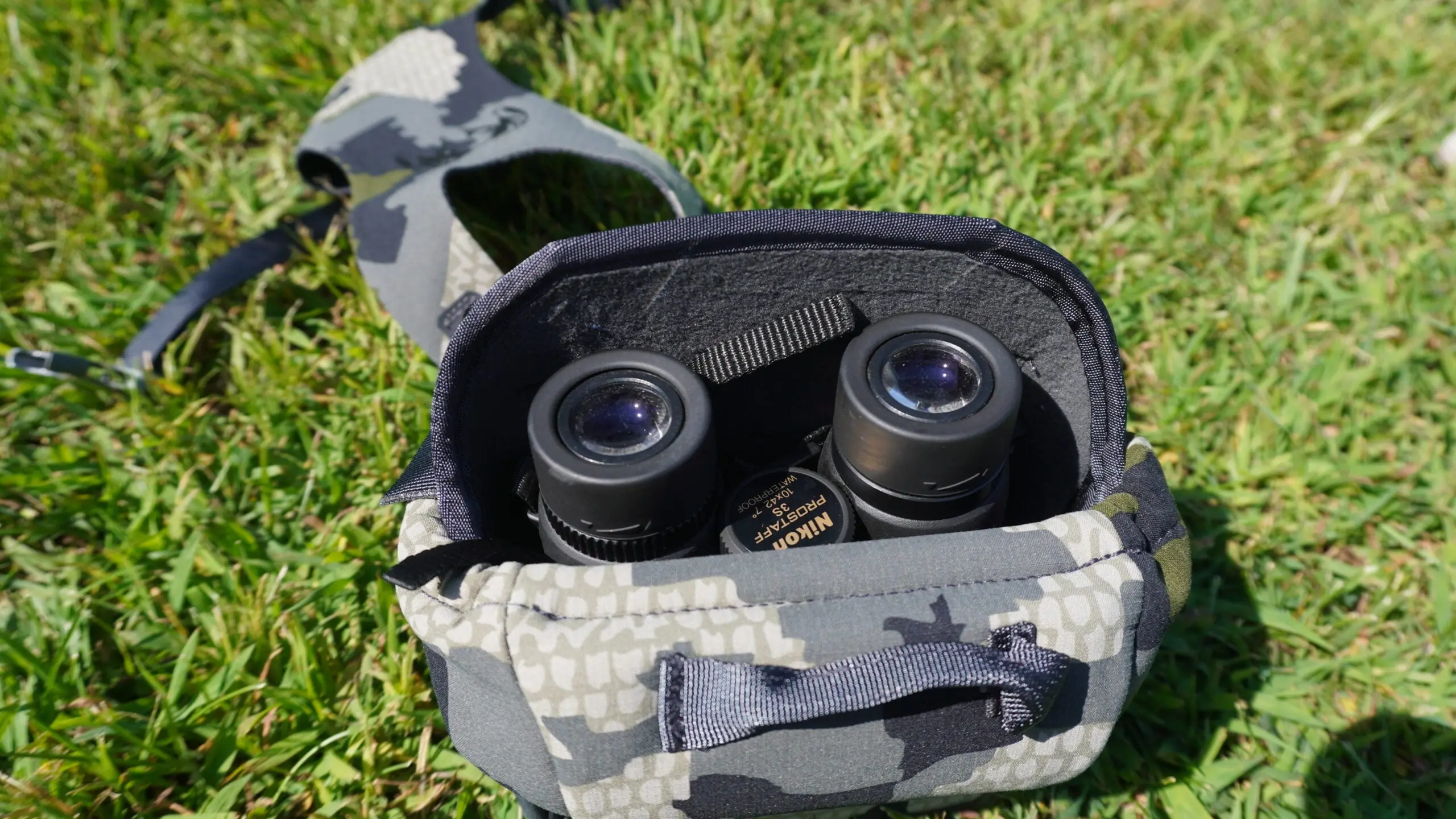 KUIU Pro binocular harness with binos inside on grass