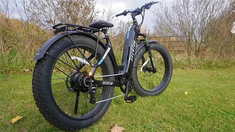 The black Aventon Aventure.2 electric bike on a grassy lawn. 