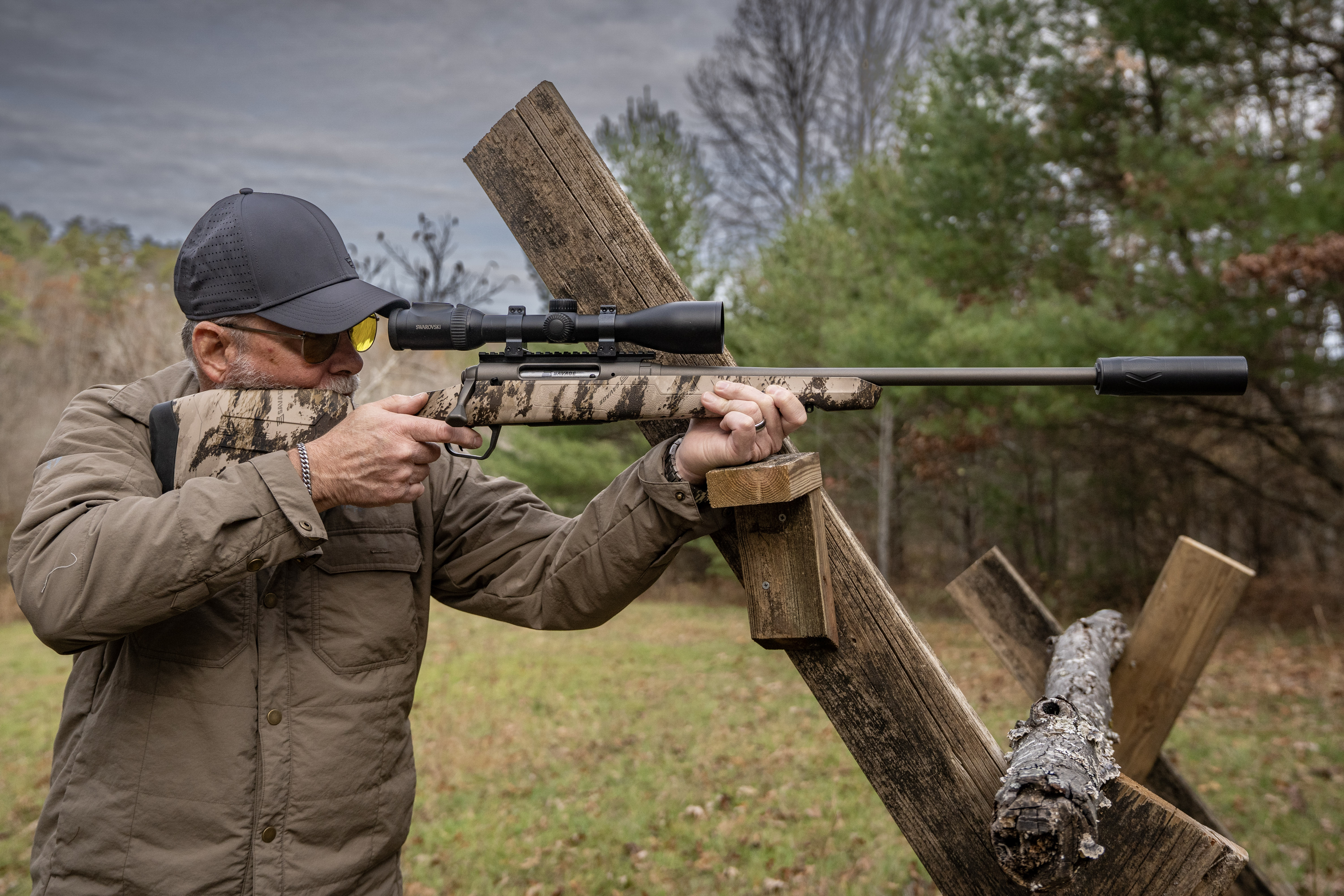 A man shooting for accuracy with a rifle resting on a barricade. 