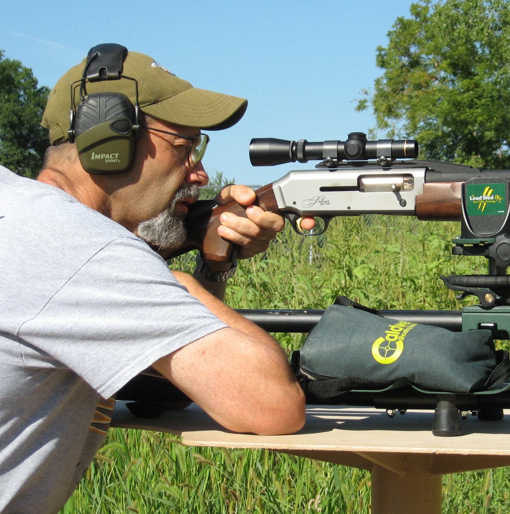Shooter fires a Browning slug from a bench rest with woods in background