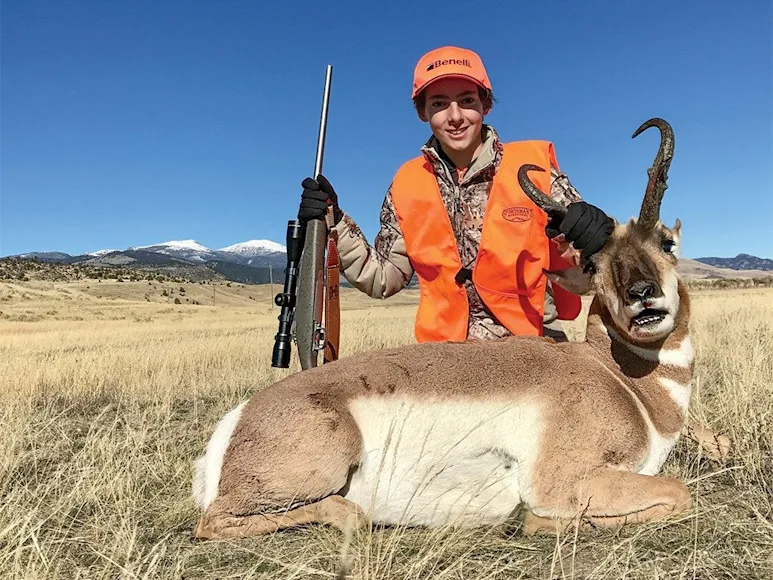 young hunter next to antelope