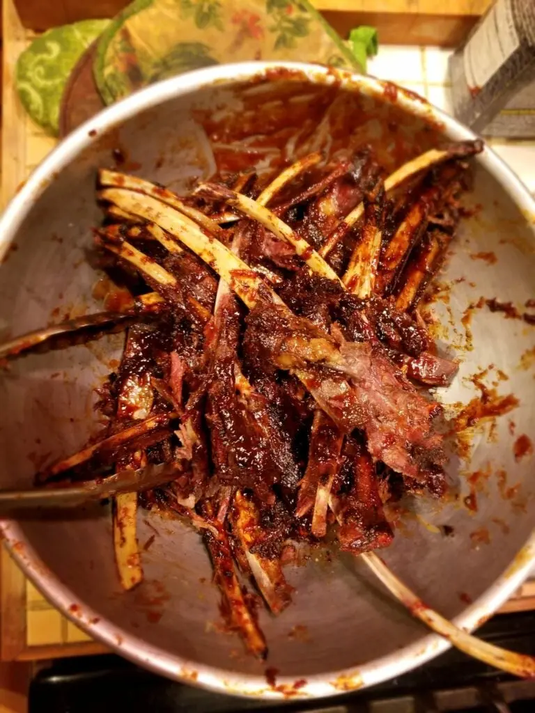 Bowl of deer ribs with barbecue sauce.