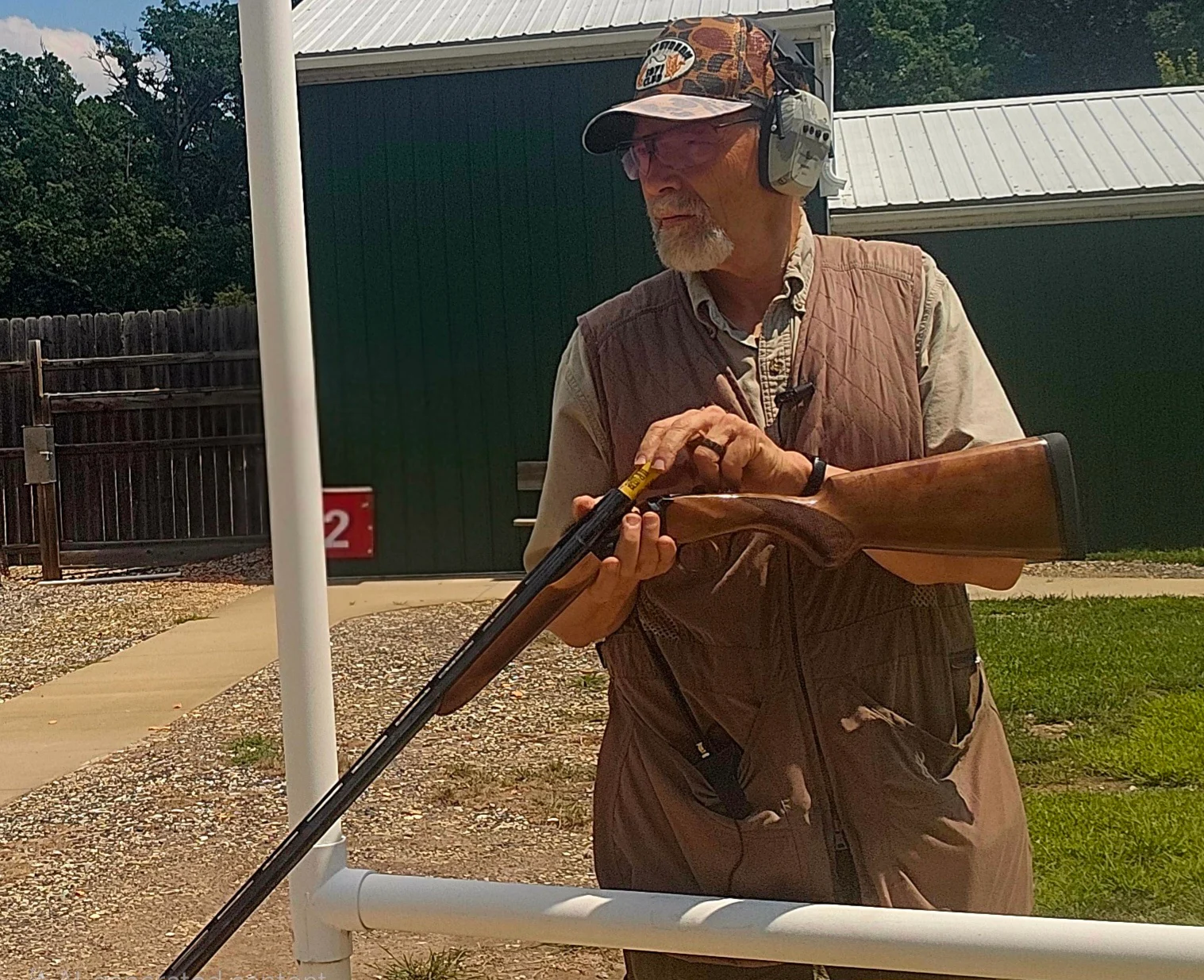 A shooter loads the new Akkar High Noon shotgun on a sporting clays range.