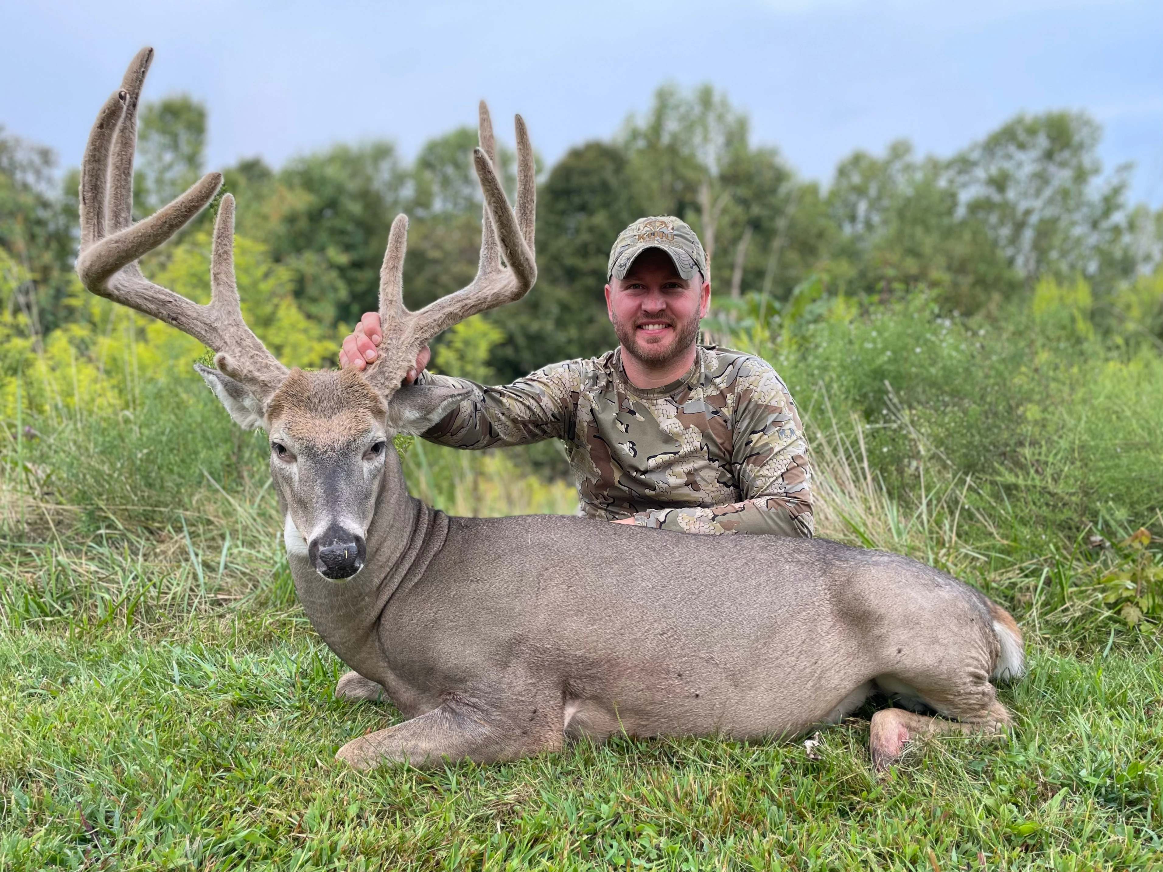 Kentucky hunter Jason Taylon sits on the ground and shows off a big velvet 8-point buck he took in Missouri. 