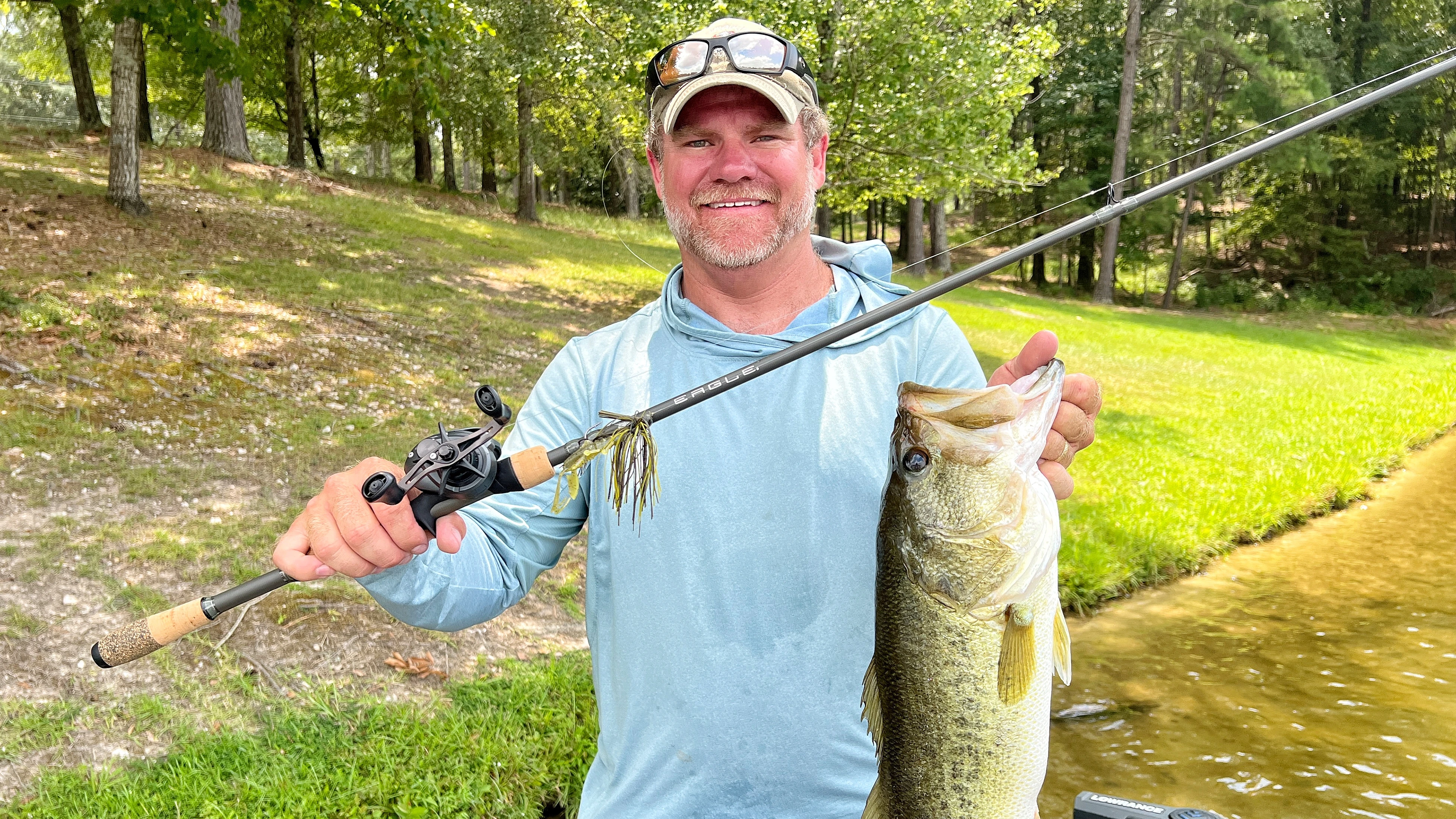 Angler holding up bass and fishing rod