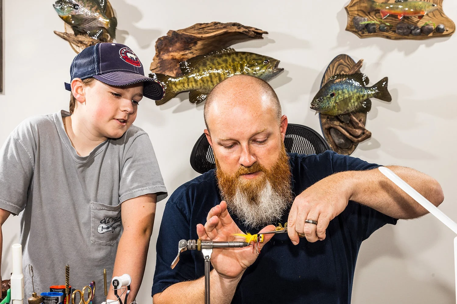 Bennett Bailes watches his father tie a fly