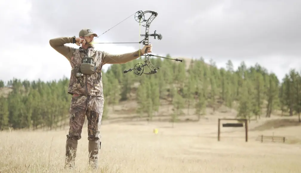 Guy shooting bow at target