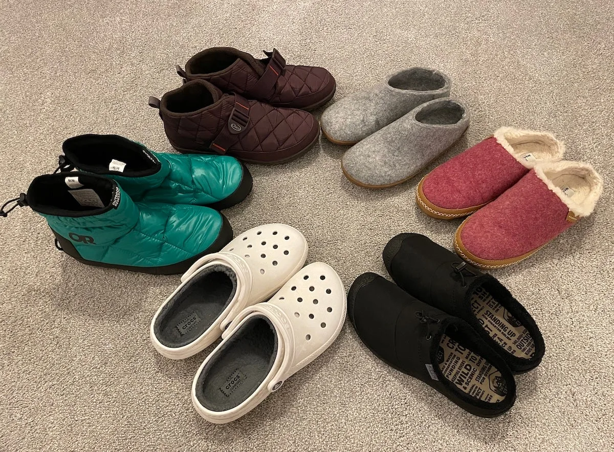 Six pairs of indoor outdoor slippers arranged on carpet during our testing