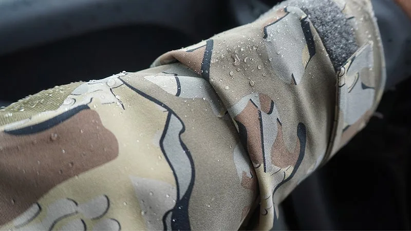 Water beaded up on the arm of a hunting rain jacket with a black background. 