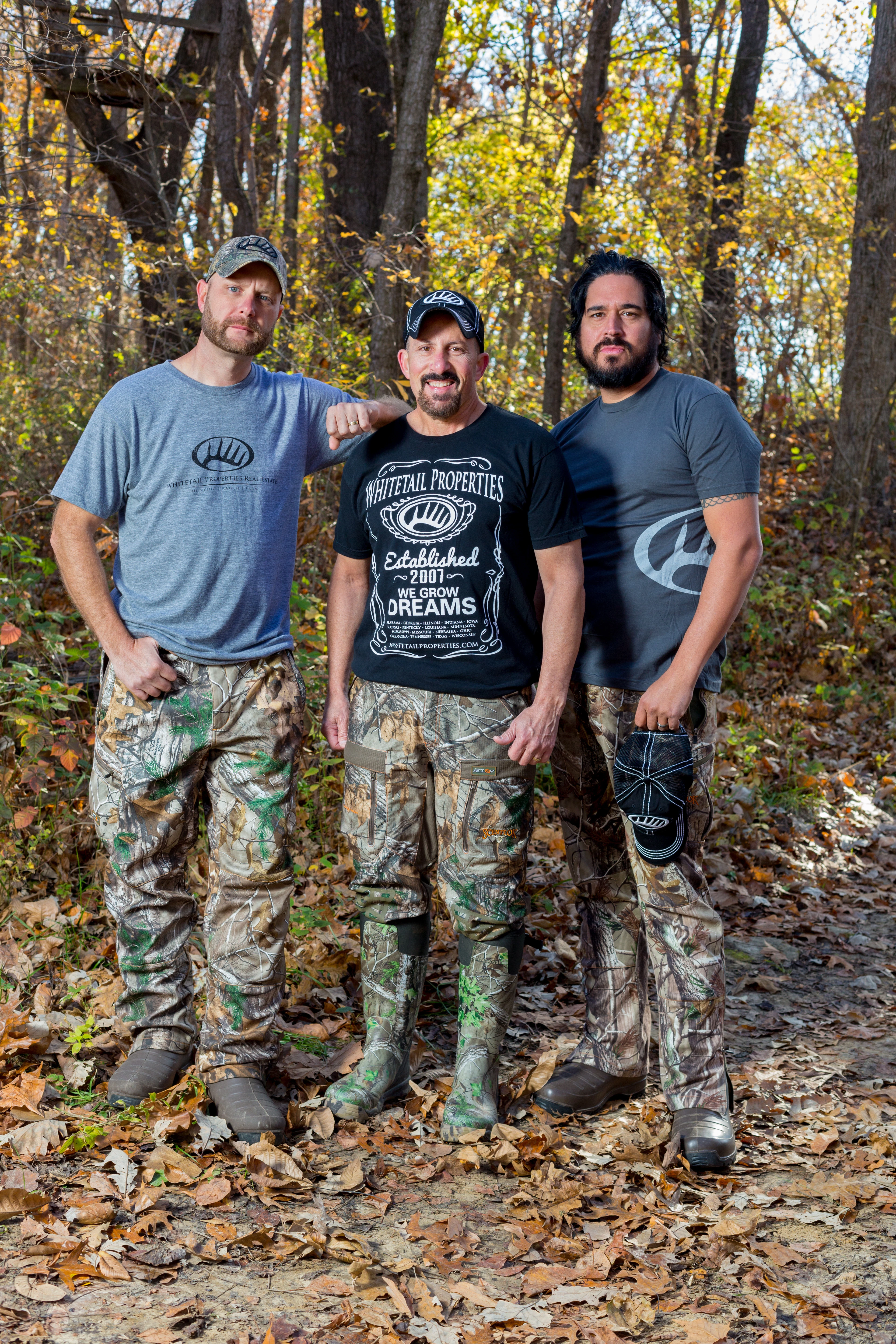 Whitetail properties founders Dan Perez, Paul Sawyer, and Pete Alfano stand one trail in the woods. 