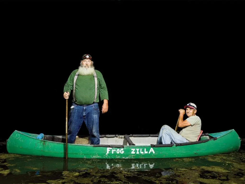 two men in fishing canoe for frogs