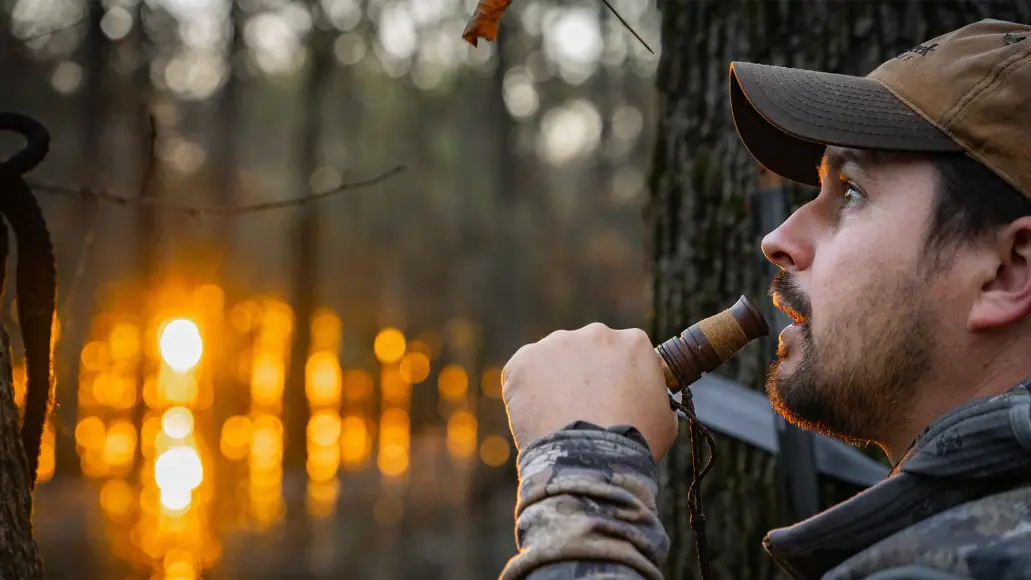 Hunter duck calling in flooded timber