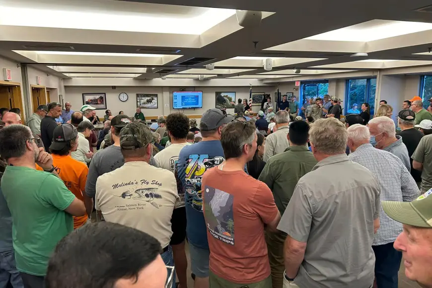 Fly fishermen gather in a room to protest proposed regulation changes. 