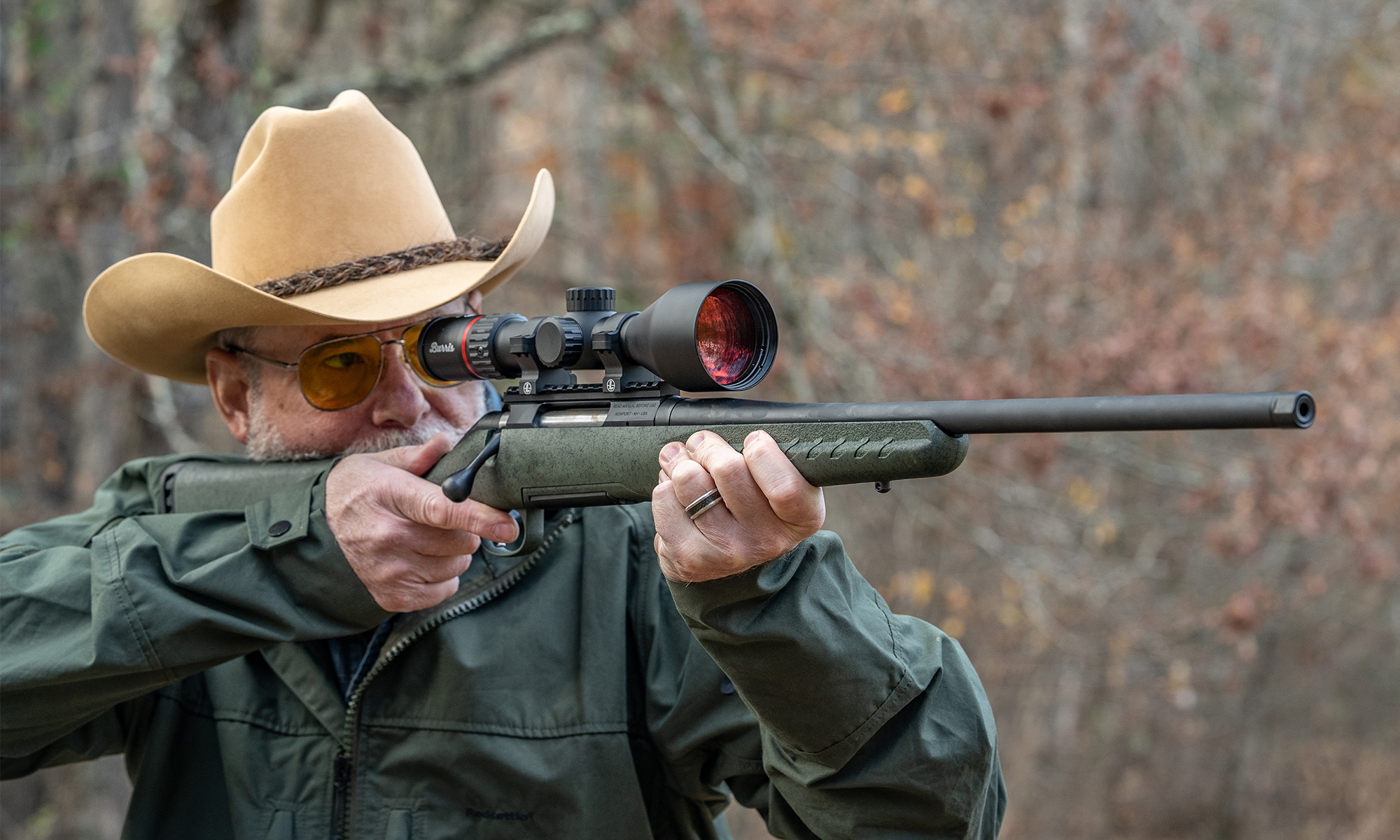A man shoots a Glenfield Model A rifle in the woods. 