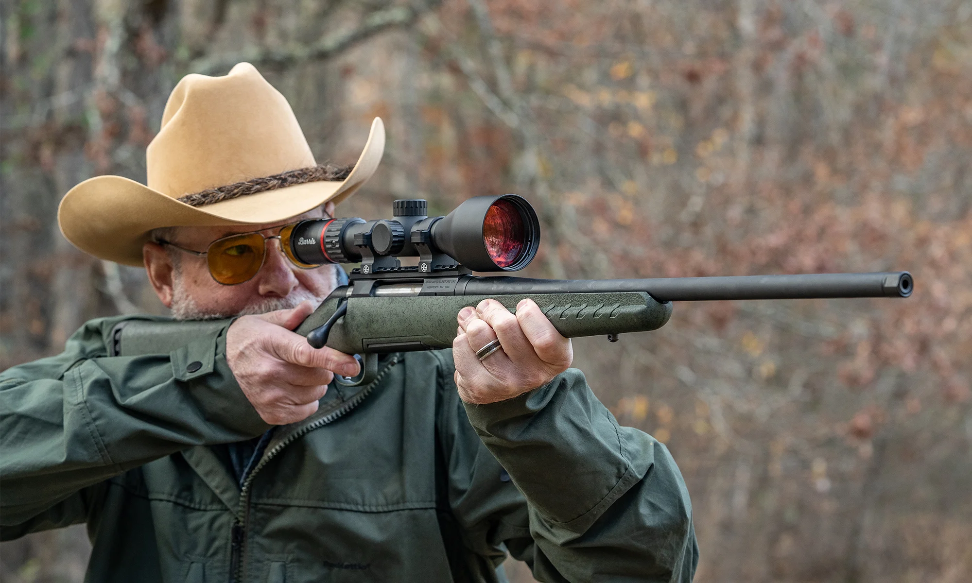A man shoots a Glenfield Model A rifle in the woods. 