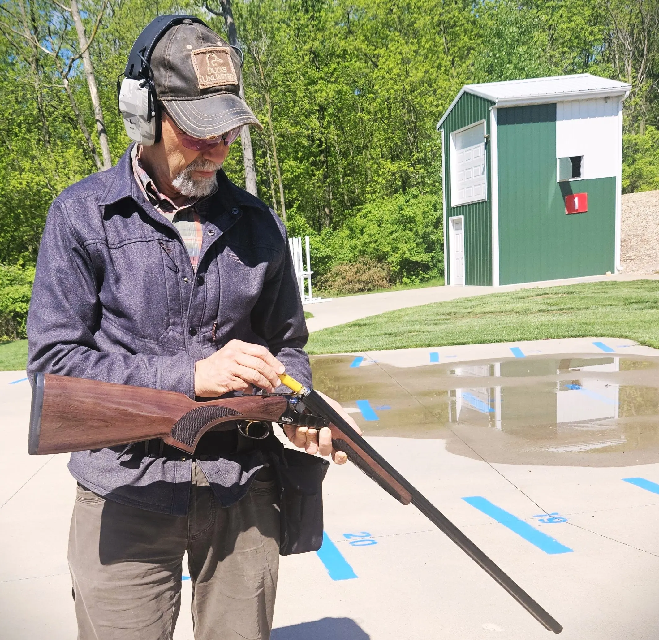 A shooter loading the Tristar Phoenix side-by-side shotgun on the skeet range