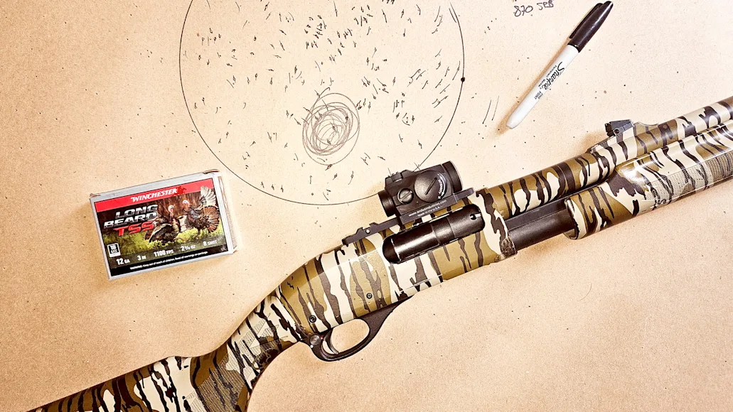 A shotgun and shells on a piece of paper used for patterning the gun.