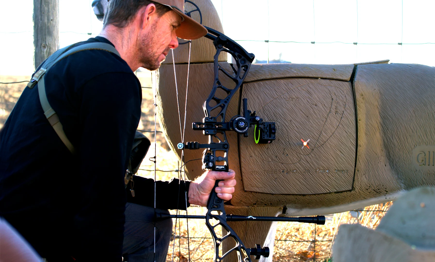 An archer holds the Bowtech Alliance compound bow while looking at an arrow in a 3D target. 