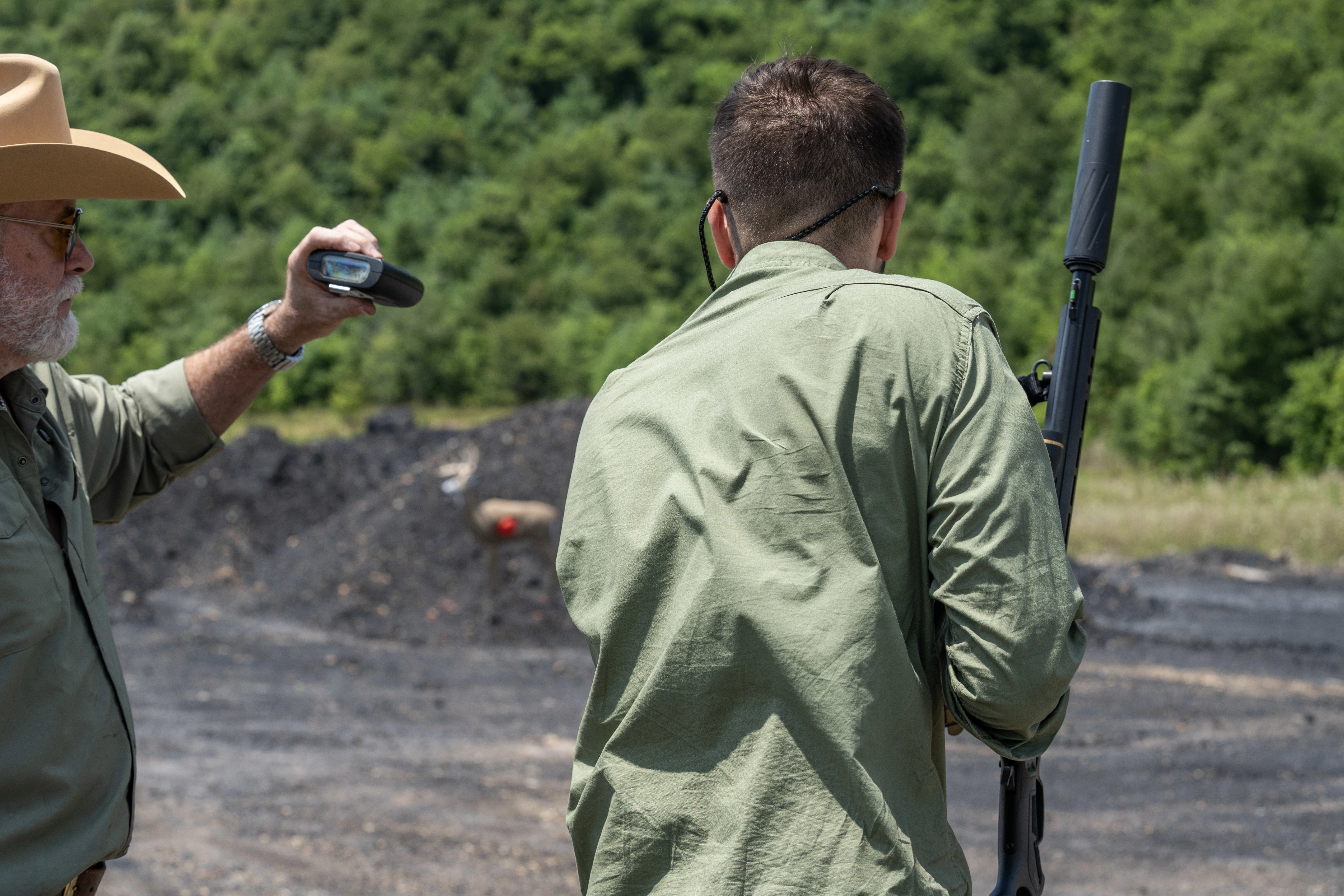 Two men prepare to take a shot at a target at a shooting range