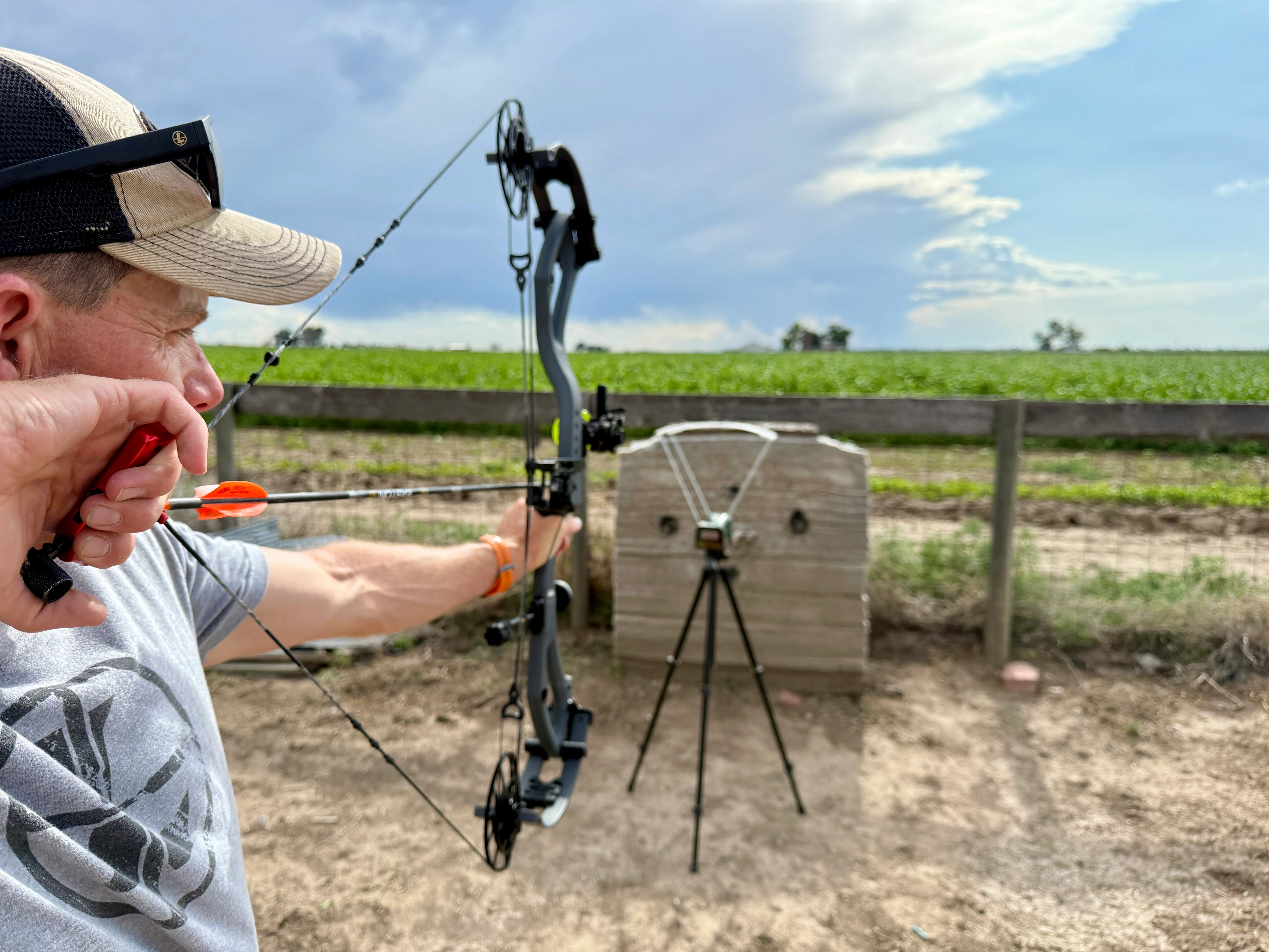 An archer shoots an arrow through a chronograph on an archery range. 