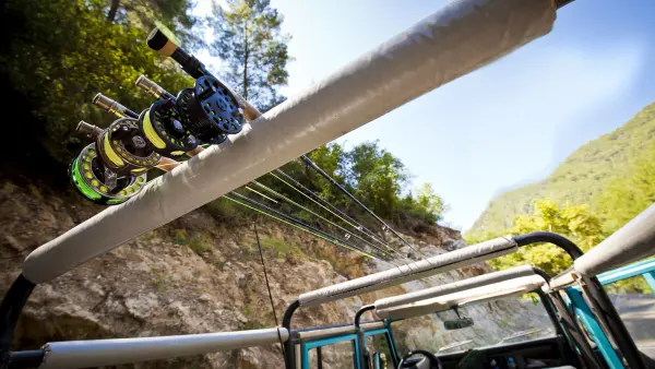 various fly rods on the roof rack of a car.