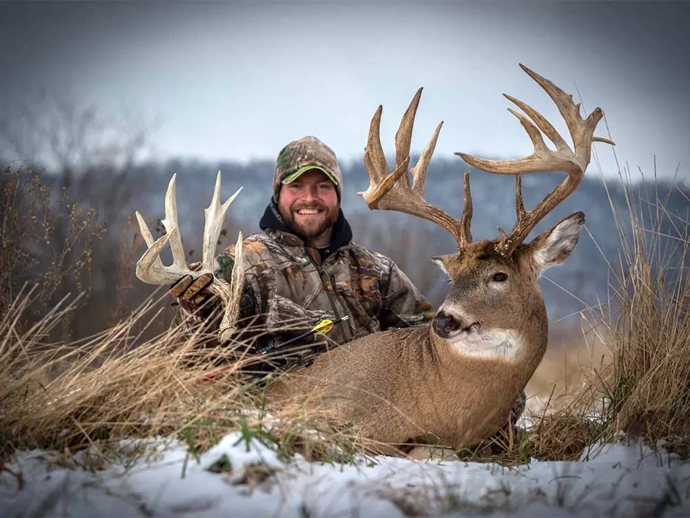 big whitetail buck in wisconsin next to hunter