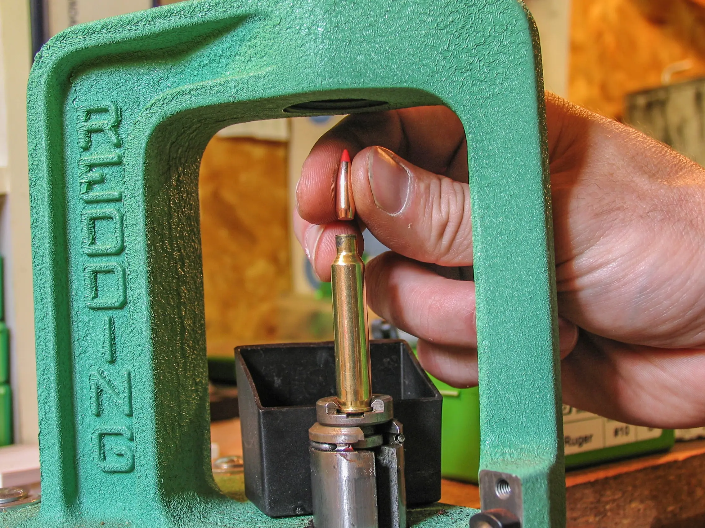 A reloading press in action.