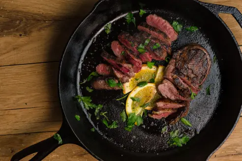 Wild good breast sliced and plated in a black skillet.