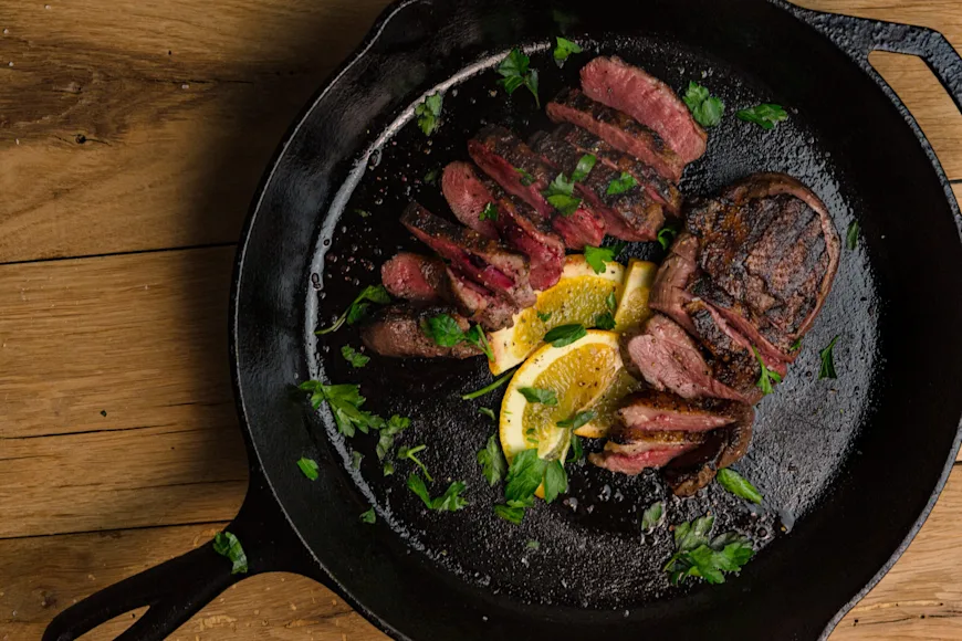Wild good breast sliced and plated in a black skillet.