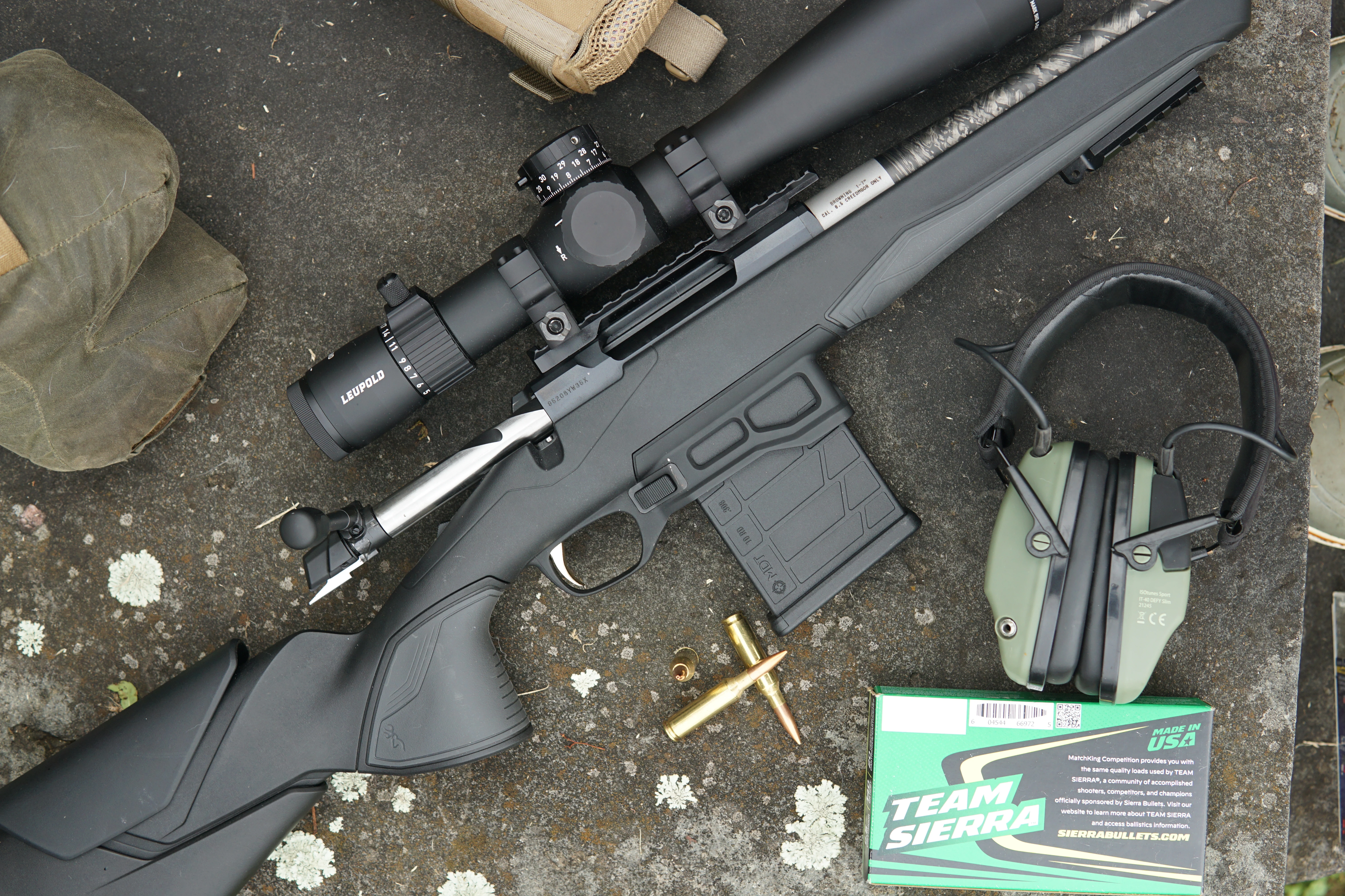 The new Browning X-Bolt 2 Target Competition Lite bolt-action rifle resting on rock with ammo and shooting gear. 