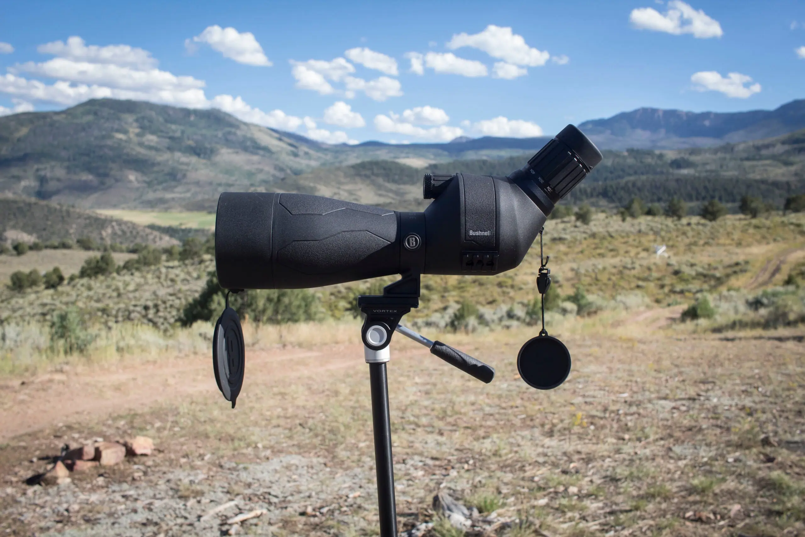 Bushnell Engaged DX spotting scope on tripod with mountains in the background