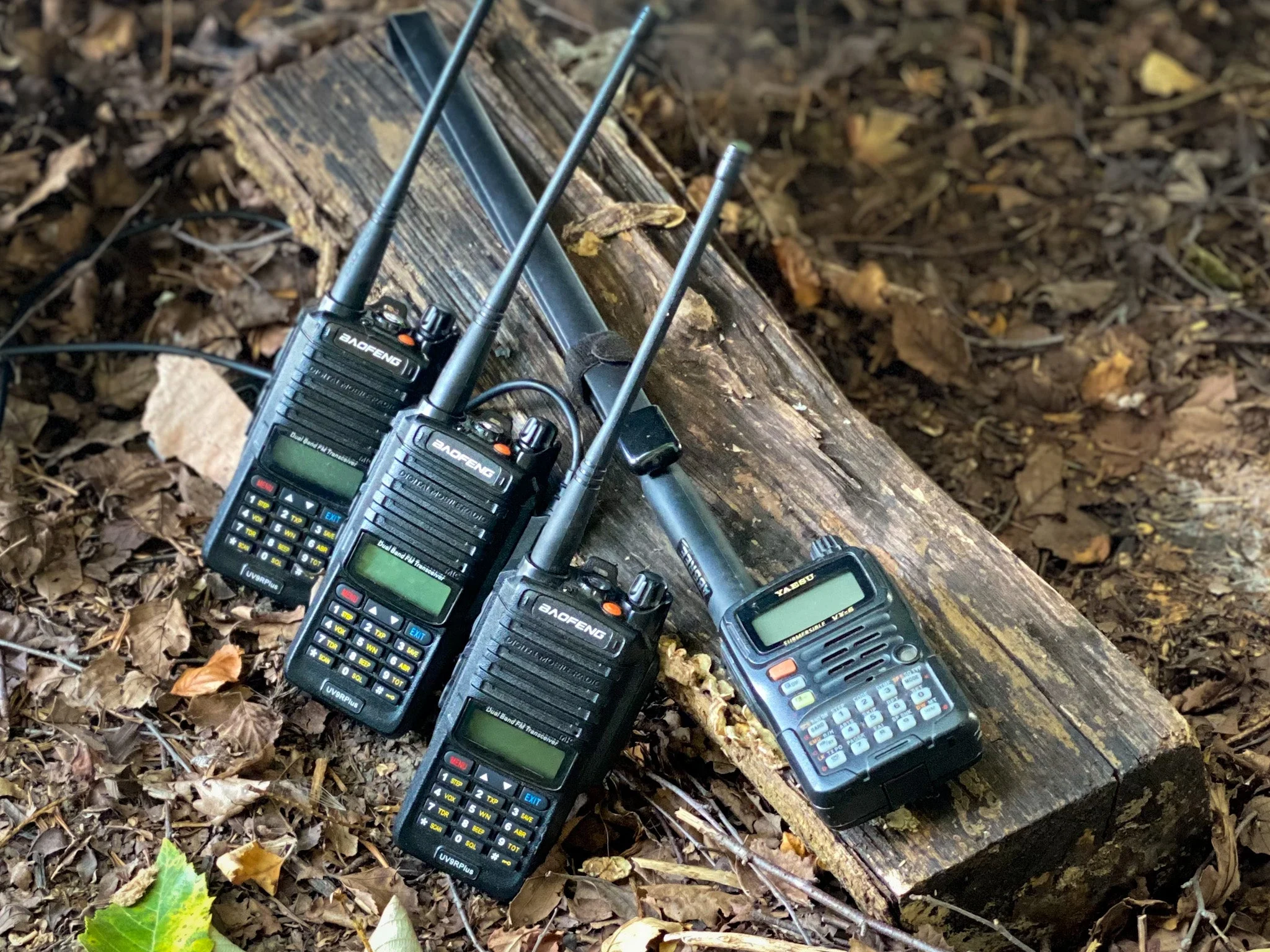 various kinds of ham radios rest on a log