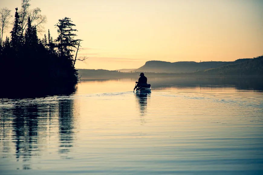 Canoeists paddle at sunset in the Boundary Waters Canoe Area Wilderness in northern Minnesota.