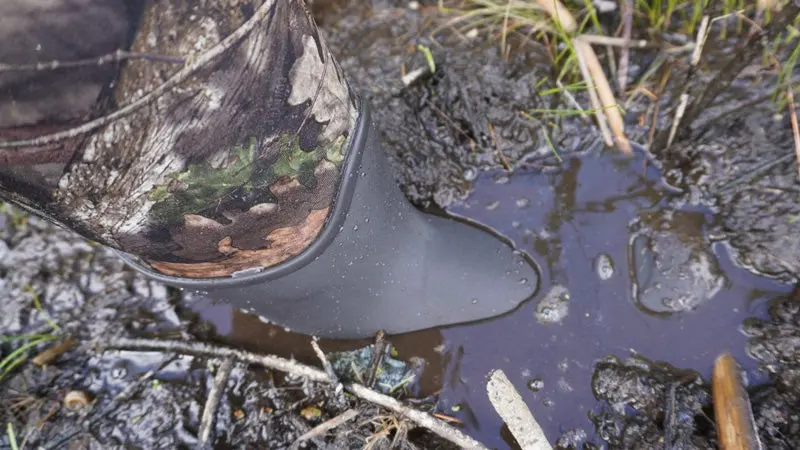 Close-up of muck boot in marsh