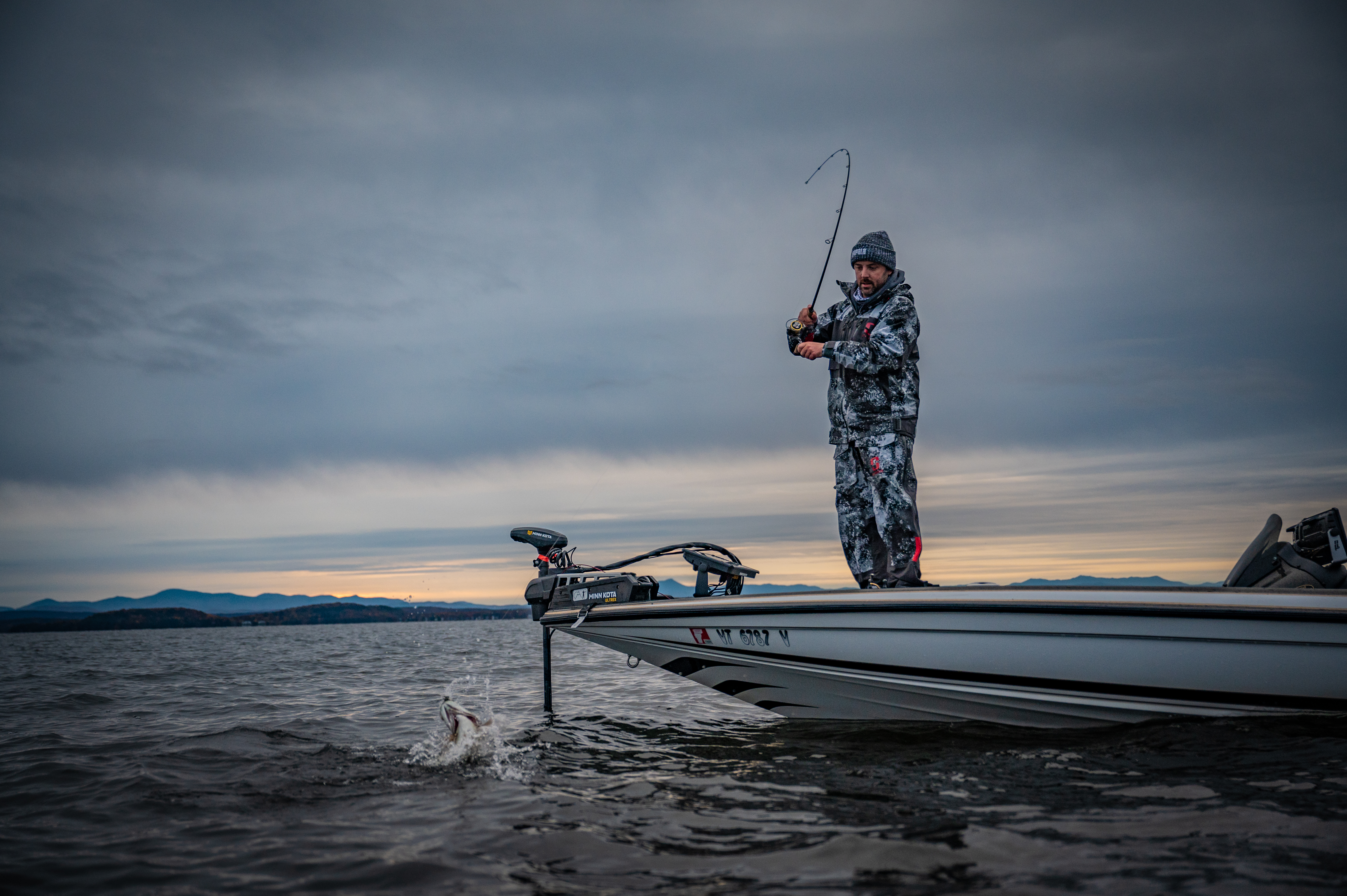 Angler fighting fish on bass boat