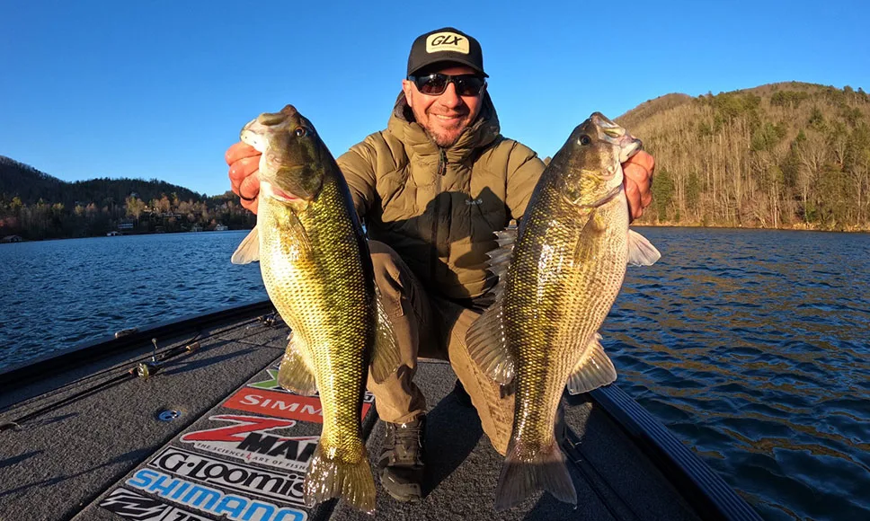 A professional angler poses with two spotted bass caught in Georgia.