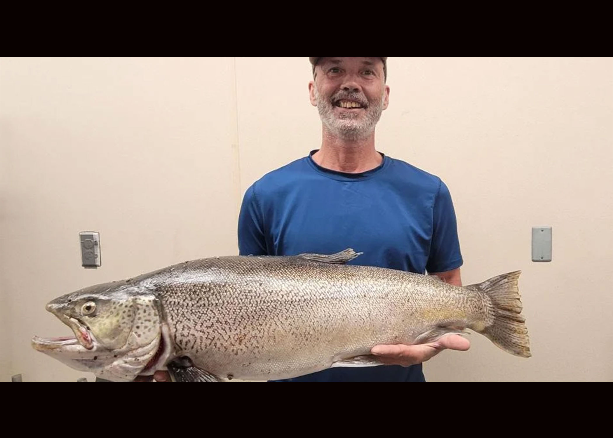 An angler poses with a record tiger trout. 
