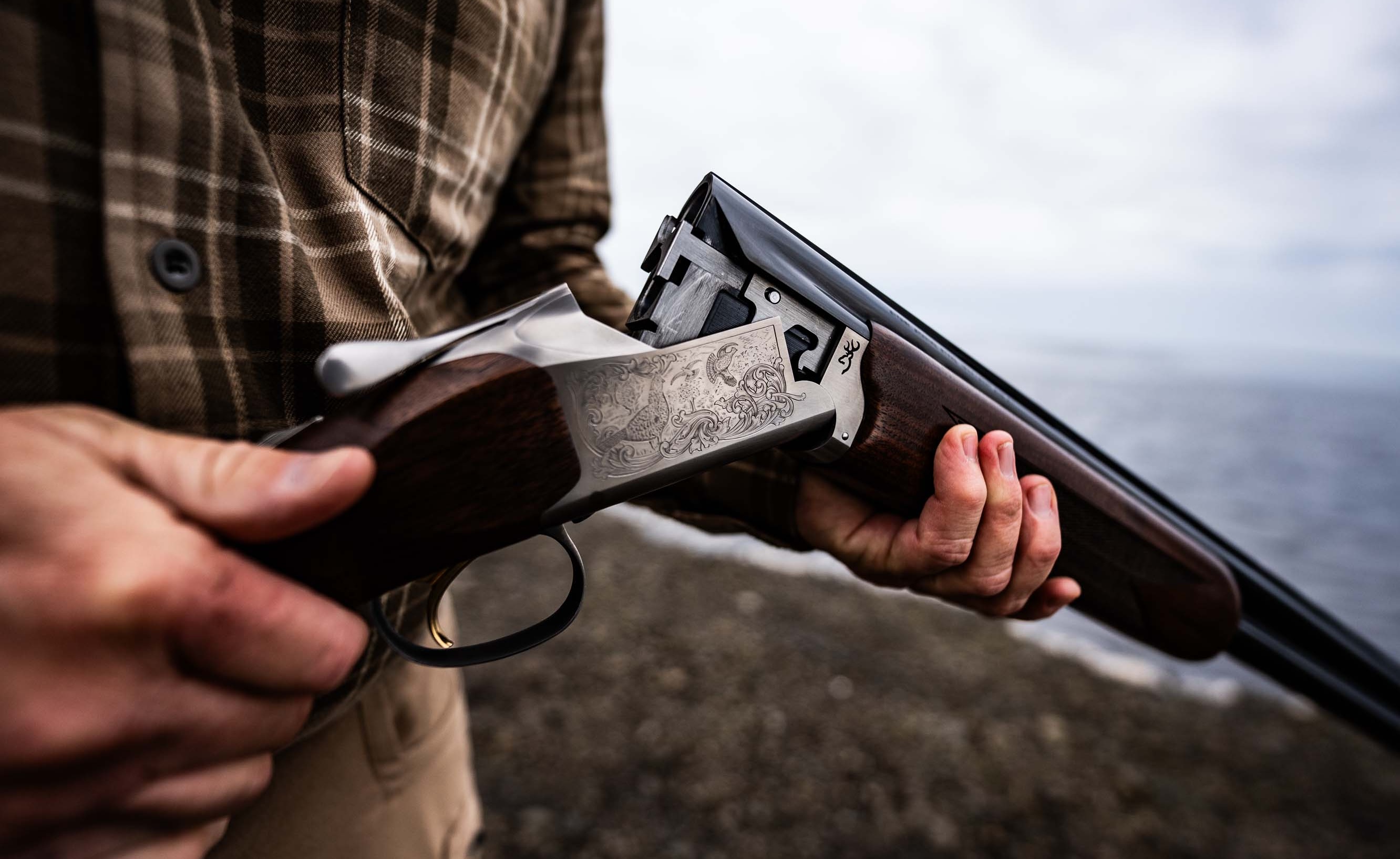 A man holds the new Browning Citori 825 shotgun in a field. 