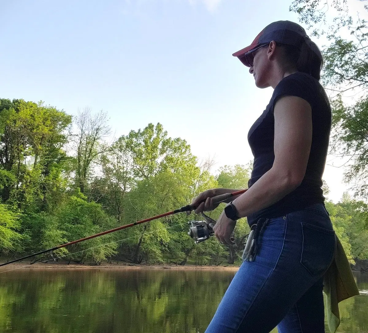 Female angler casting fishing rod and reel combo