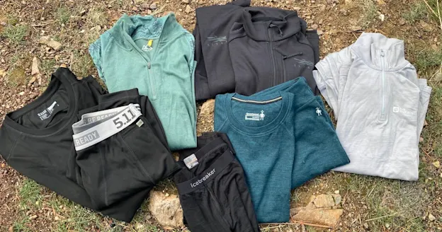 Assorted long johns and base layers spread out on grass