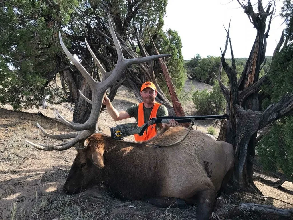 Hunter poses next to a giant elk. 